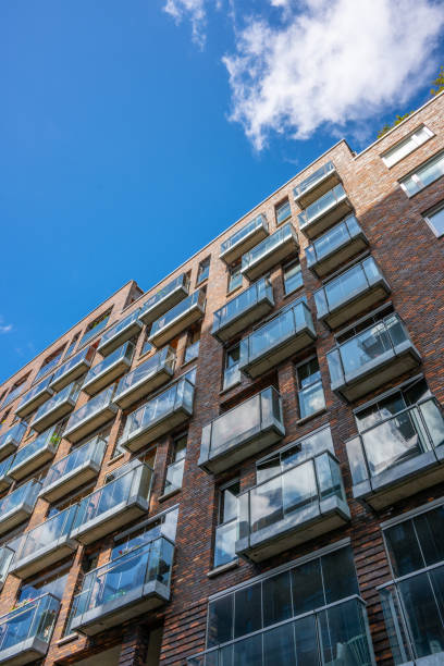istock Looking up the facade if a brick and glass apartment complex.. 2180316563
