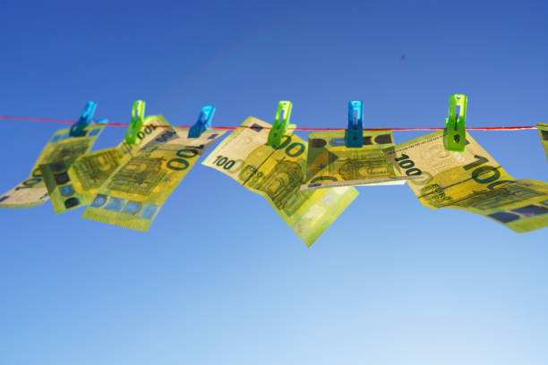 Money laundering. Washed Euro note paper during drying. 100 euros Banknote are drying on clothesline. One hundred Money of European Union Euro note on blue sky background. One hundred Euro euro bills.