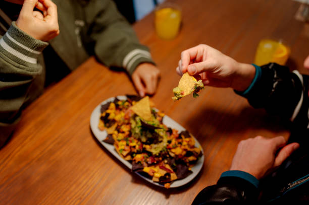 istock People eating Mexican nachos 2180320533