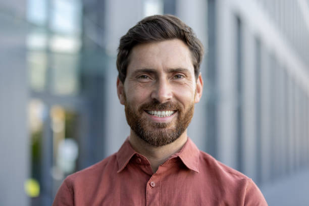 istock A man with a beard and a red shirt is smiling 2180321992