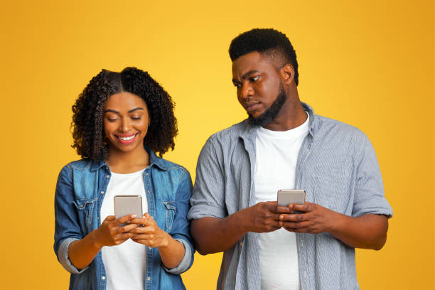 istock Jealous black guy spying oh girlfriend's phone, trying to read messages 2180322661