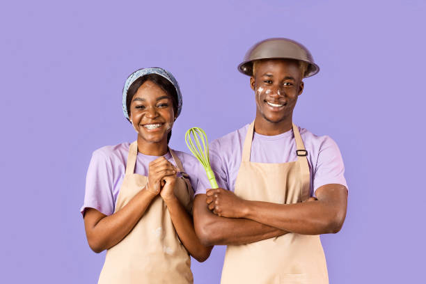 istock Joyful black couple with faces covered in flour baking together on violet background 2180322770