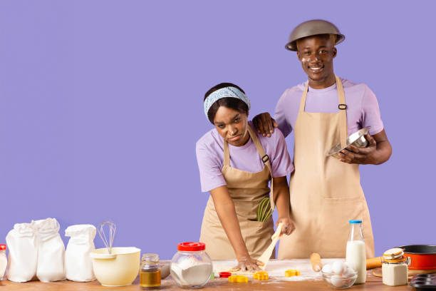 istock Happy guy and exhausted lady covered in flour from head to toe while cooking on violet background 2180322824