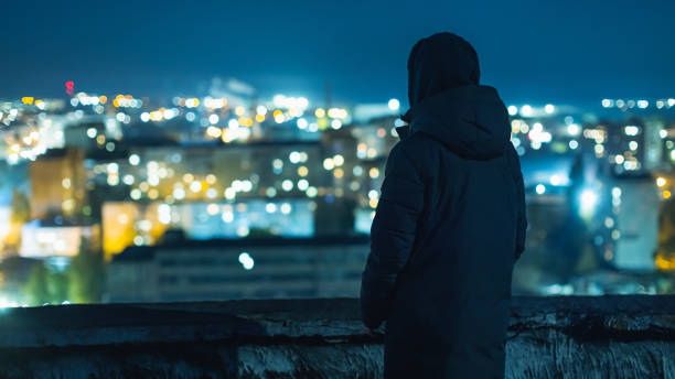 istock Man silhouette against night city background. 2180322828