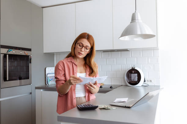 istock A pensive female thinking about high prices while holding bills 2180327348
