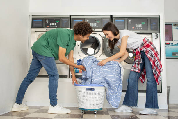 Couple doing laundry together in a modern laundromat on a sunny day