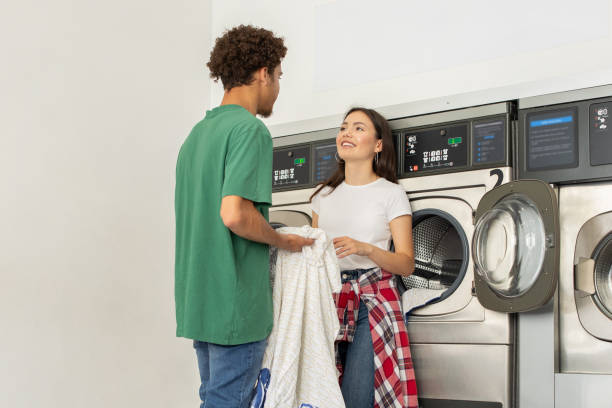istock Couple interacting at a laundromat while doing laundry together in the afternoon 2180328244