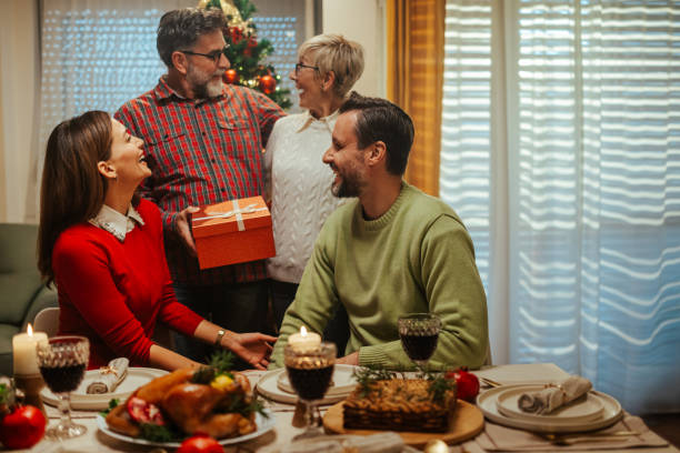 istock Happy family exchanging christmas presents at dinner table 2180331391