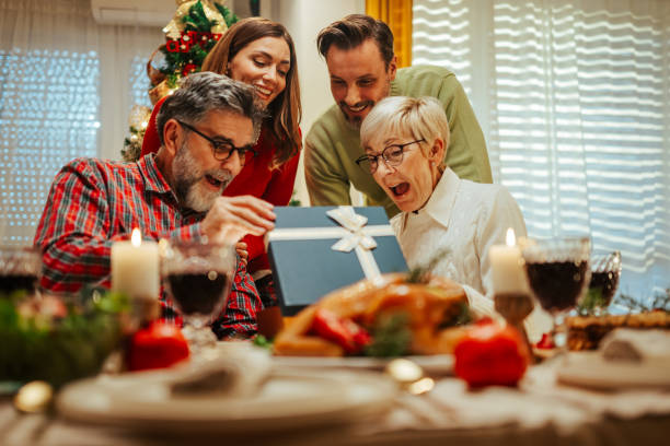 istock Family having christmas dinner together opening present 2180331394