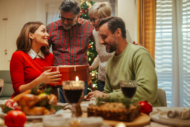 istock Family exchanging christmas presents during christmas dinner 2180331436