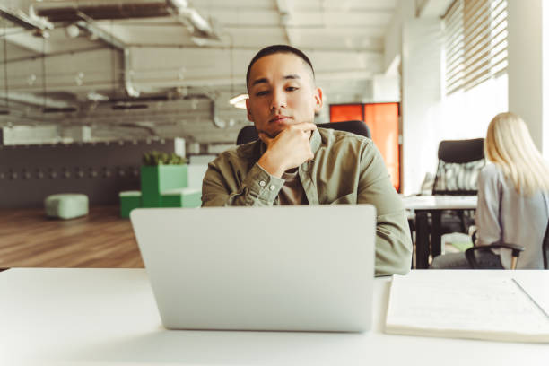 istock Focused asian businessman working on laptop in modern office 2180338160
