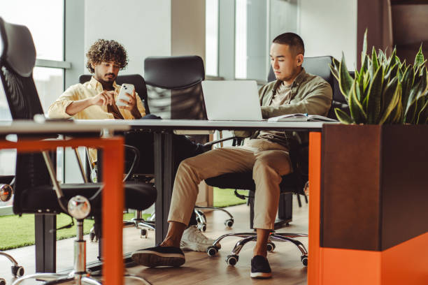 istock Two young businessmen working in modern open space office 2180342458