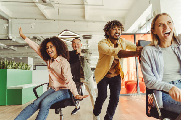 istock Coworkers having fun pushing each other on chairs in the office 2180342508
