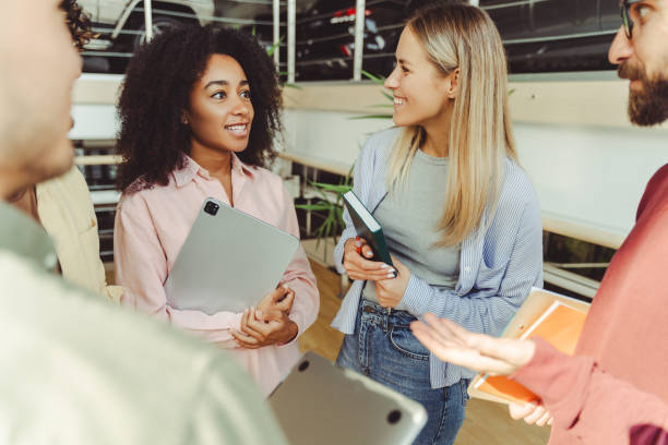 istock Diverse group of students having discussion in busy university hallway 2180342551