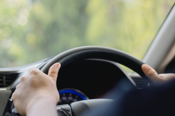 istock A young man's hand is held on the black steering wheel while he is driving in the car on a highway, a road trip travel concept. Safe Driving, Travel safely. 2180346971