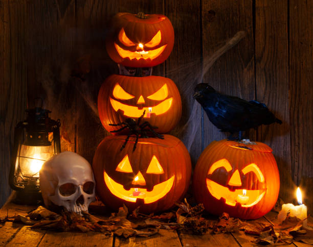 istock Halloween Jack-o-Lantern Pumpkins on rustic wooden background 2180350655