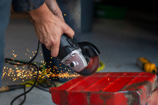 istock A skilled worker using a power tool to cut metal, creating sparks in a workshop environment during daylight hours 2180353706
