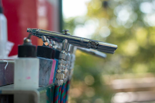 Airbrush tools lined up at a creative workspace during a sunny afternoon in a vibrant studio