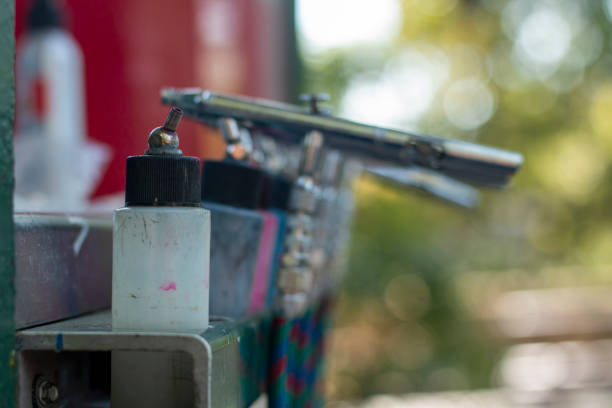 istock An airbrush and paint container on a workbench in a vibrant outdoor setting during daylight 2180353721