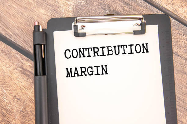 istock CONTRIBUTION MARGIN yellow notepad with text on the page. white pen 2180354946