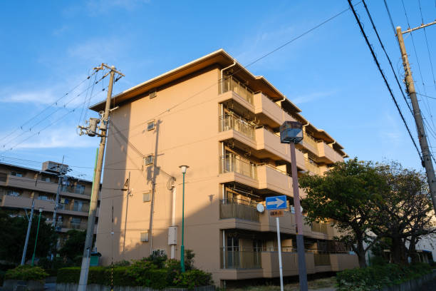 Short beige apartment building lit by the late afternoon sun.