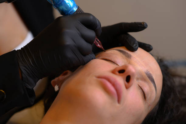 istock Beautician applying permanent eyebrow makeup on latino woman 2180372969