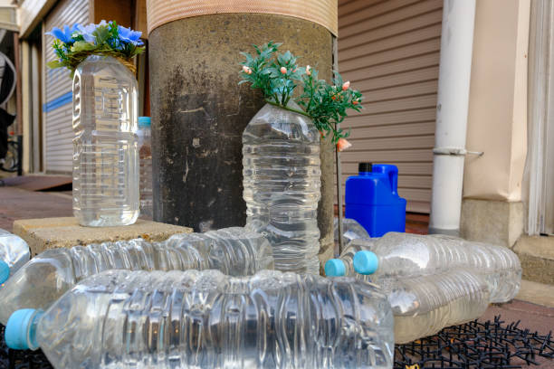 Group of bottles of water on a footpath to discourage stray cats from coming near.