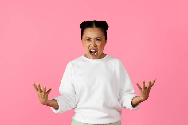 istock A young person expresses strong emotions against a pink background 2180375775