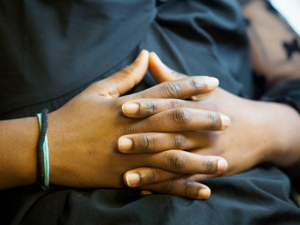 istock Young woman clasping hands on lap in thought 2180378854