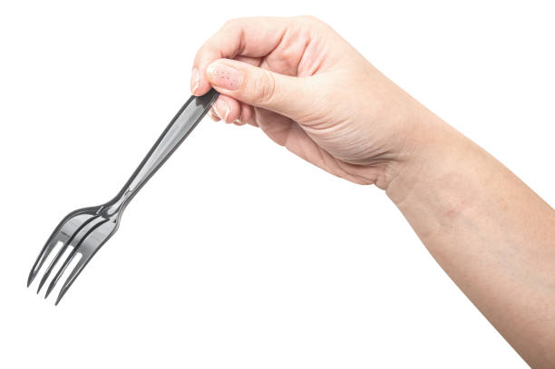 istock Female hand holding a black plastic fork isolated on white background. 2180383338