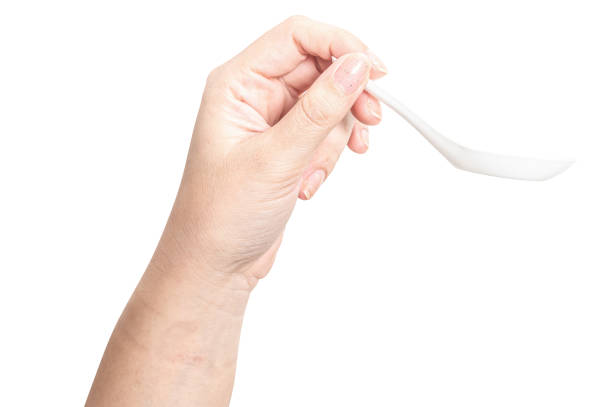 istock Female hand holding a white plastic spoon isolated on white background. 2180383360
