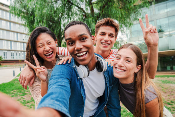 istock Group of multiracial young student people smiling and taking a selfie together. Classmates on friendly meeting. Close up portrait of happy african american teenager laughing with his cheerful friends. 2180385301