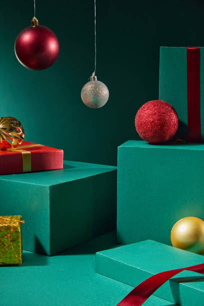 istock The image is on a luxurious emerald background, with green boxes to display the product, placed next to fruit boxes, decorated with Noel hanging balls and red ribbons to create a Christmas vibe. 2180388826