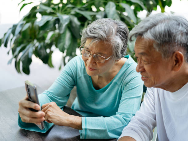 istock Senior couple looking at smartphone in a cafe 2180388989