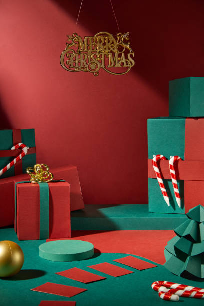 istock A Christmas vibe image sample. Display products on a green podium that are adorned with candy canes, bright present boxes, paper pine trees, and Christmas balls on the red background. 2180389331
