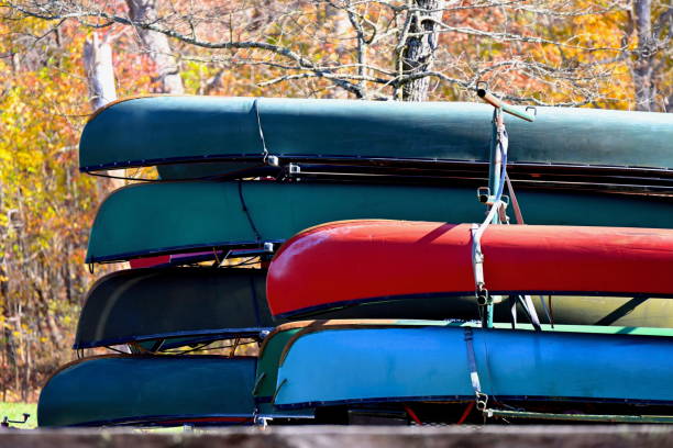 A trailer carrying a variety of colorful canoes awaits paddlers for a day of canoeing.