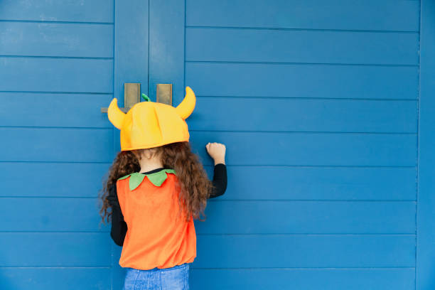 Little girl in dinosaur costume running with buckets.