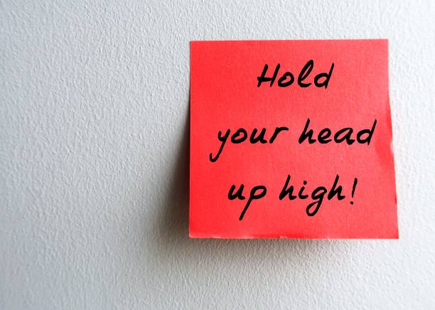 istock Stick note on gray copy space background HOLD YOUR HEAD UP HIGH!, self reminder to be confident and proud when you did your best respect yourself in times of difficulty, failure or embarrassment 2180396549