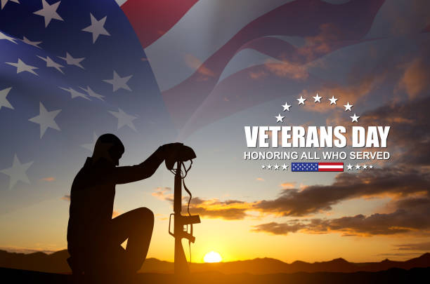 istock Silhouette of a soldier kneeling down with USA flag 2180397040