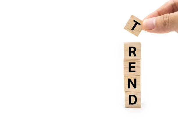 istock Hand putting wood cube block with TREND text isolated on white background. Copy space. marketing monitor, business planning. 2180397623