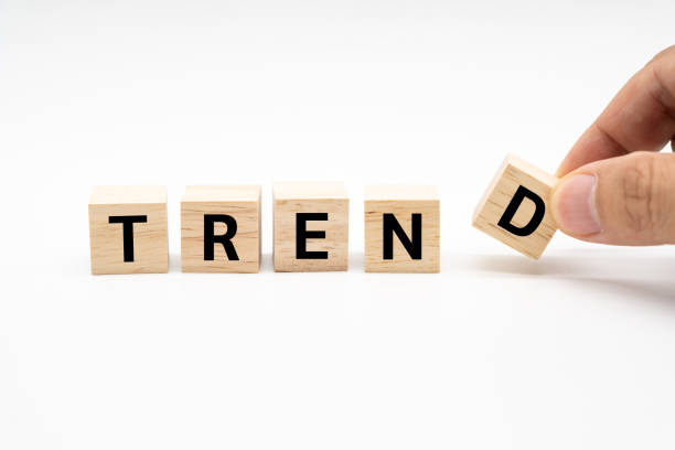 istock Hand putting wood cube block with TREND text isolated on white background. Copy space. marketing monitor, business planning. 2180397636