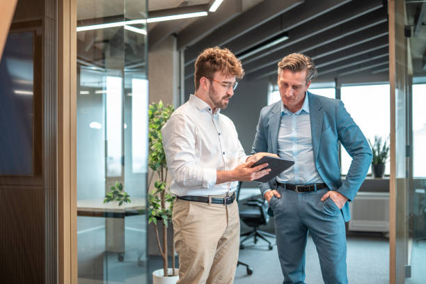 istock Diverse Businessmen Collaborating with Tablet in Office 2180398074