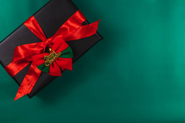 istock Gift box with red bow and Merry Christmas, on green background 2180400483