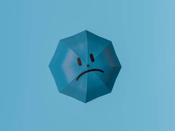 istock Blue umbrella showing sad face representing blue monday concept 2180410939