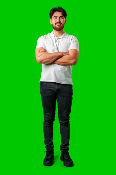 istock A smiling young man with a beard poses against a bright green background 2180411436