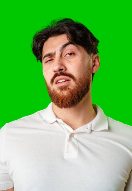 istock A young man with a beard showing a serious expression against a vibrant green background 2180414166