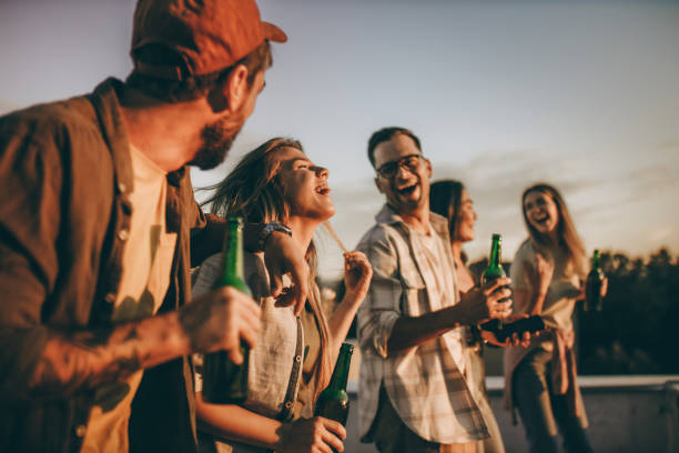 istock Cheerful friends having fun while drinking beer on a roof. 2180414679