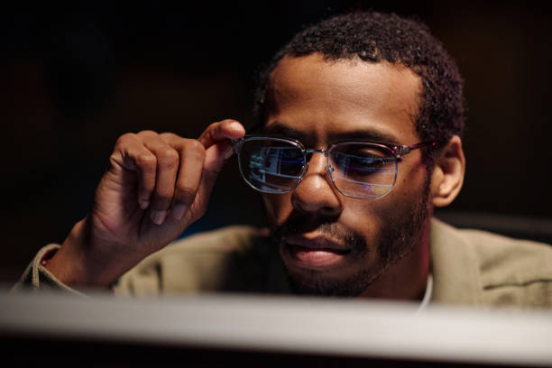 istock African American Man Adjusting Glasses at Workstation 2180416962