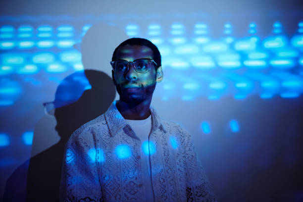 istock Portrait of Man Wearing Glasses Standing with Blue Light Effects 2180417785