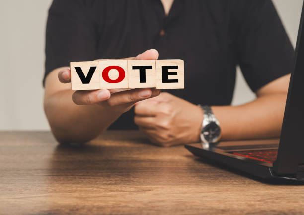 istock Hand holding vote blocks, highlighting democracy, voting, and election participation. 2180417824